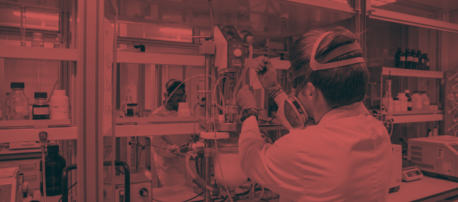 Research staff in a laboratory conducting tests while wearing a mask and protective goggles